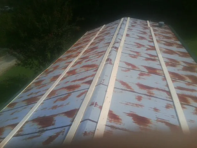 Rusted metal roof panels with new wood purlins before replacement — Storm Damage Roof Repair in Van Buren by Roofing Brothers