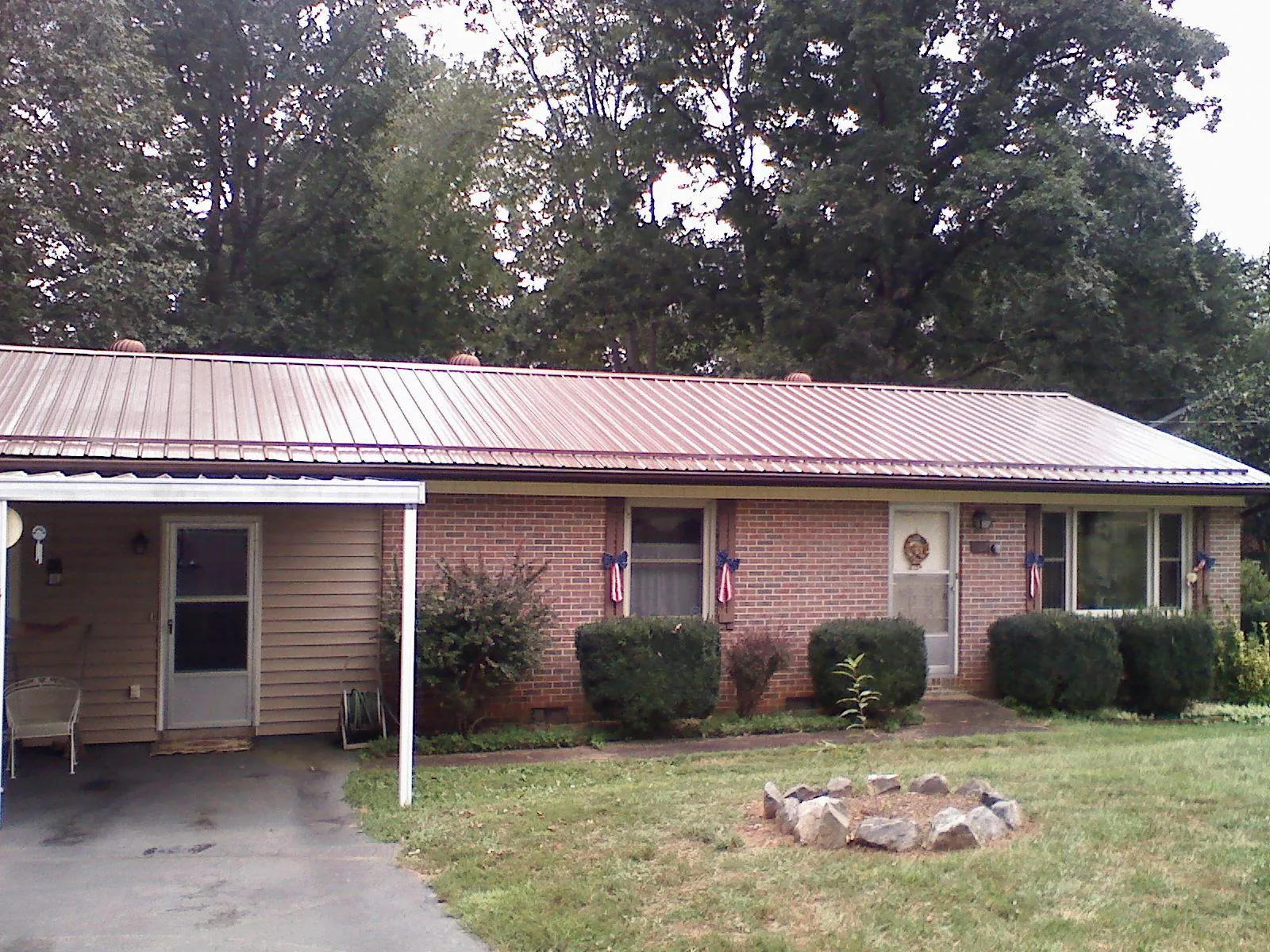 Bronze metal roof and carport on a brick ranch home — Roof Repair work by our crew in Van Buren